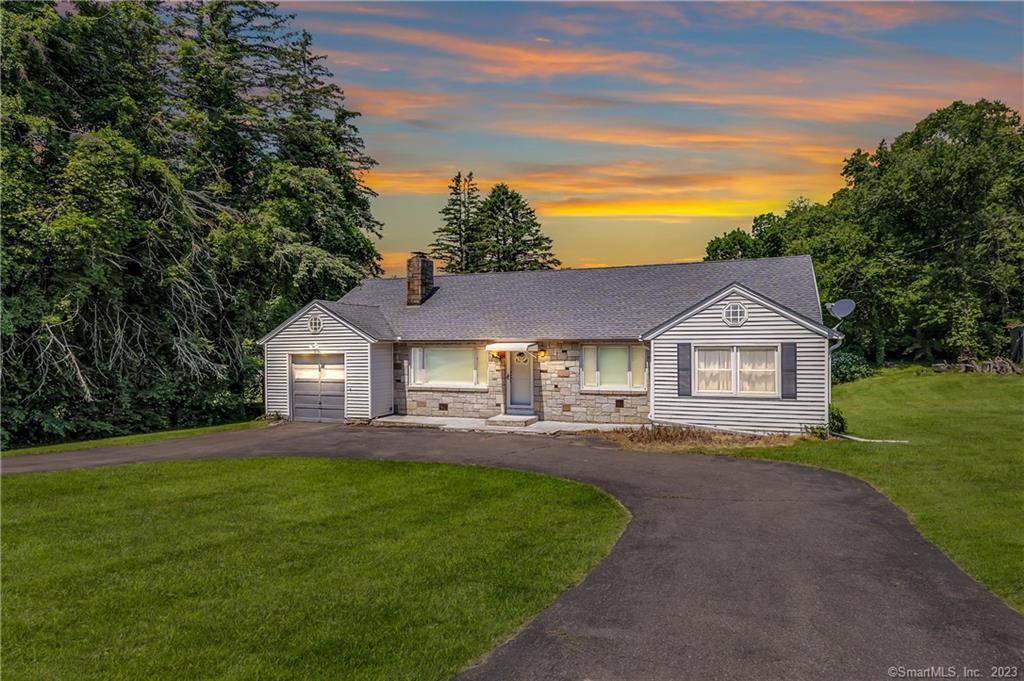 a front view of a house with a garden and yard