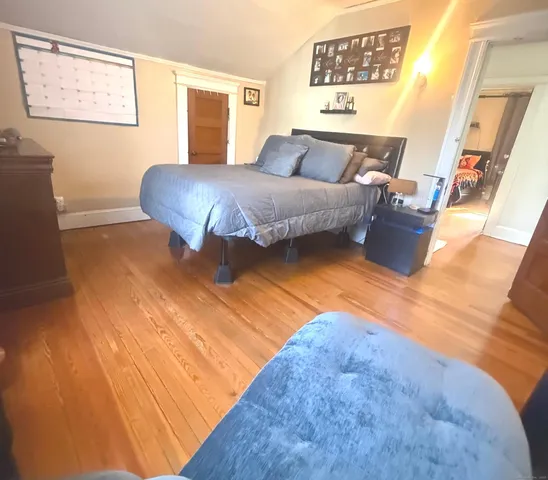 a living room with a bed furniture and a wooden floor