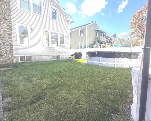 a view of a house with backyard and sitting area