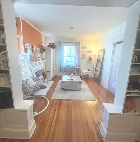 a living room with furniture and a wooden floor