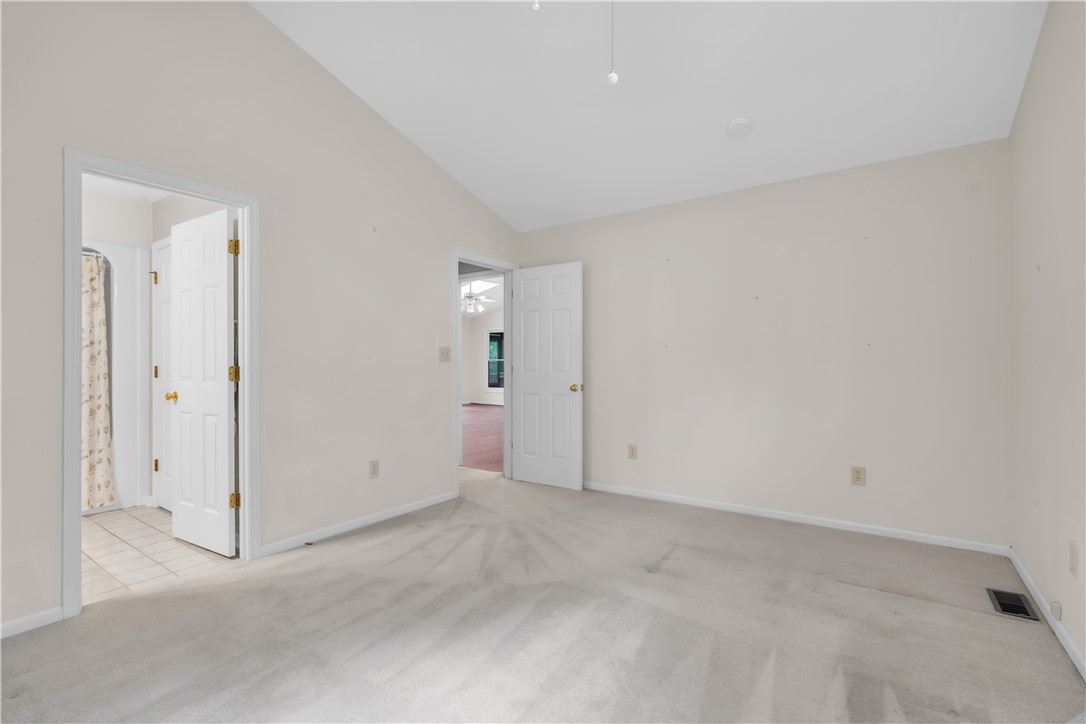 149 Inlet Pointe Drive Anderson, SC 29625 - Photo 22 of 43 A vaulted ceiling enhances the spacious feel of this bedroom, featuring carpeted flooring and an adjacent tiled bathroom.