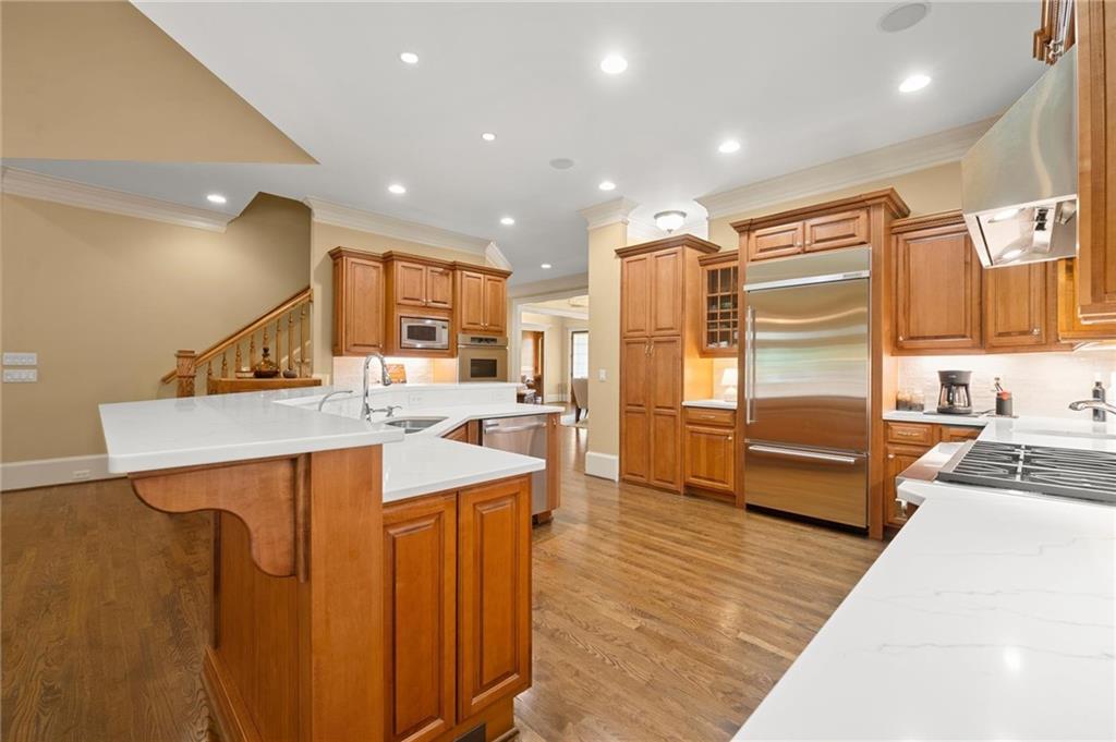 322 Edwards Brook Lane Canton, GA 30115 - Photo 29 of 99 a large kitchen with stainless steel appliances a stove a sink dishwasher and a refrigerator with wooden floor