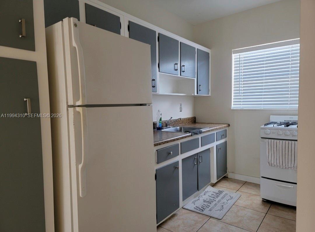 620 76th Street, Unit 11 Miami Beach, FL 33141 - Photo 8 of 14 a white refrigerator freezer sitting inside of a kitchen