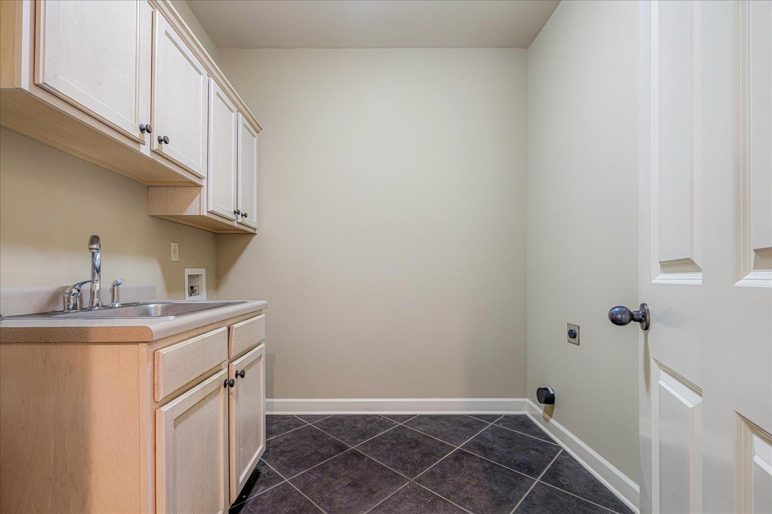 4597 Whisper Spring Drive Collierville, TN 38017 - Photo 24 of 40 Laundry area featuring dark tile patterned flooring, hookup for a washing machine, and cabinet space