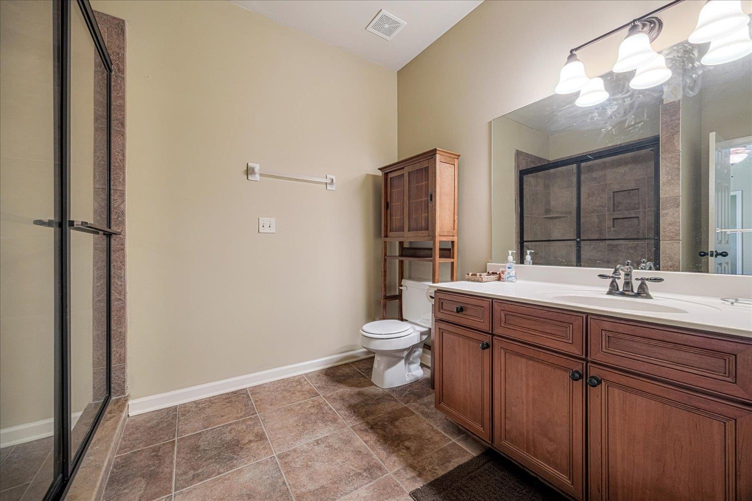 4597 Whisper Spring Drive Collierville, TN 38017 - Photo 29 of 40 Bathroom with a stall shower, vanity, and dark tile patterned flooring