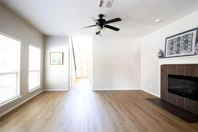 a view of empty room with wooden floor and fireplace