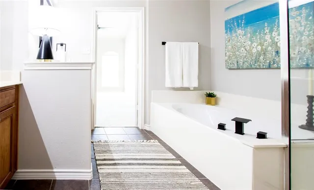 a bathroom with a bathtub sink and mirror