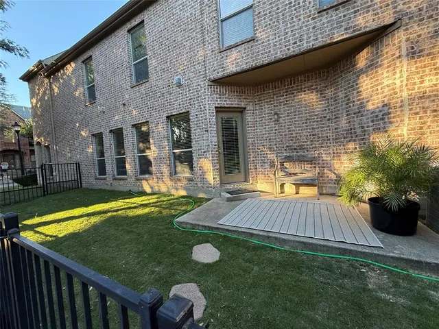 a view of a patio with table and chairs potted plants and large tree