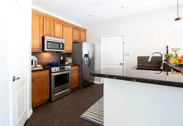 a kitchen with stainless steel appliances a stove microwave and refrigerator