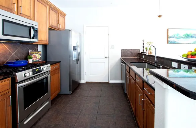 a kitchen with stainless steel appliances a stove and a refrigerator