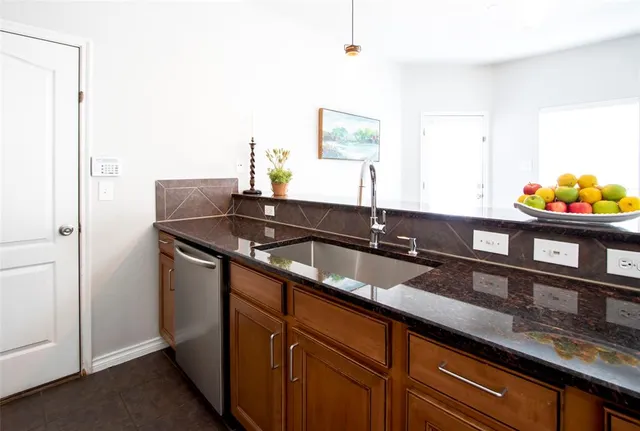 a kitchen with granite countertop a sink and a window