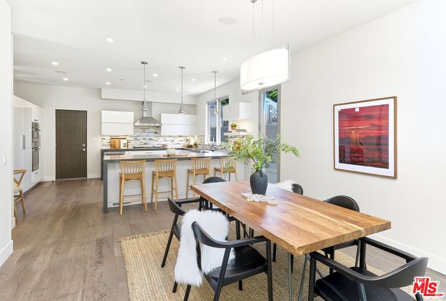 a dining room with kitchen island a table and chairs in it