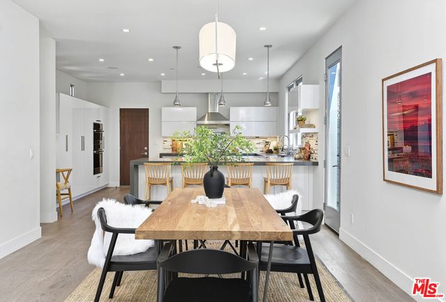 a view of a dining room with furniture a chandelier and wooden floor