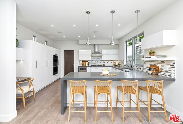 a kitchen with stainless steel appliances kitchen island granite countertop a refrigerator and microwave