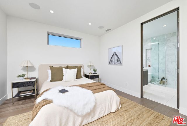 a bedroom with a large bed and a chandelier