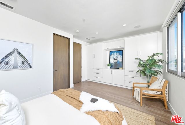 a bedroom with a bed and a potted plant