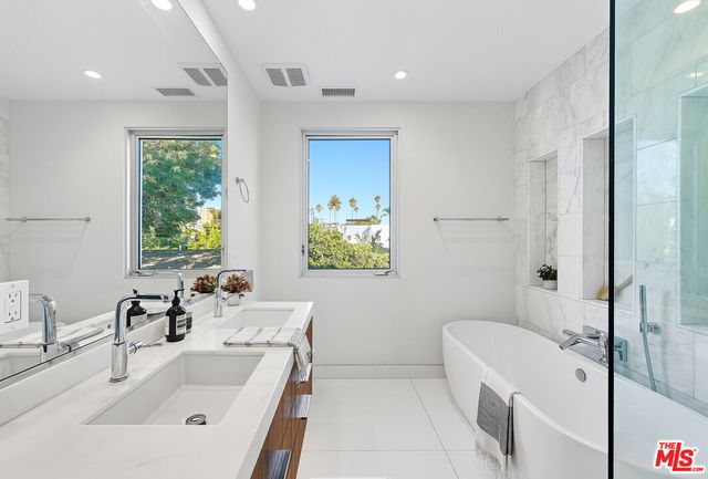 a bathroom with a tub sink and mirror