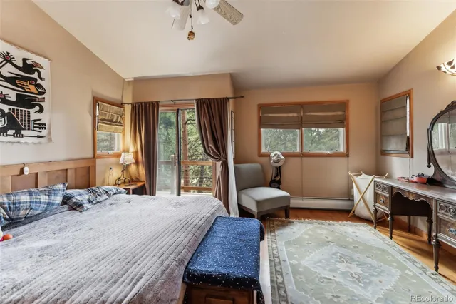 a bedroom with a bed a large window and flat screen tv