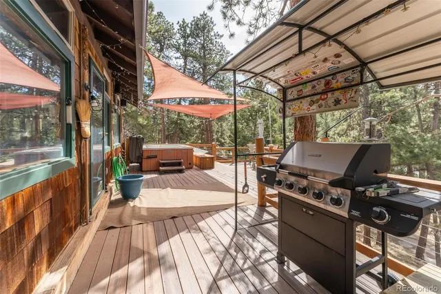 a view of a patio with couches and table and chairs with wooden floor and fence