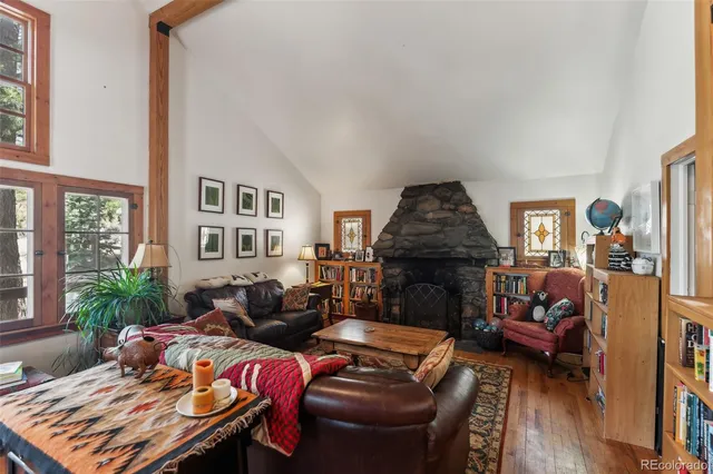 a living room with furniture a fireplace and a floor to ceiling window