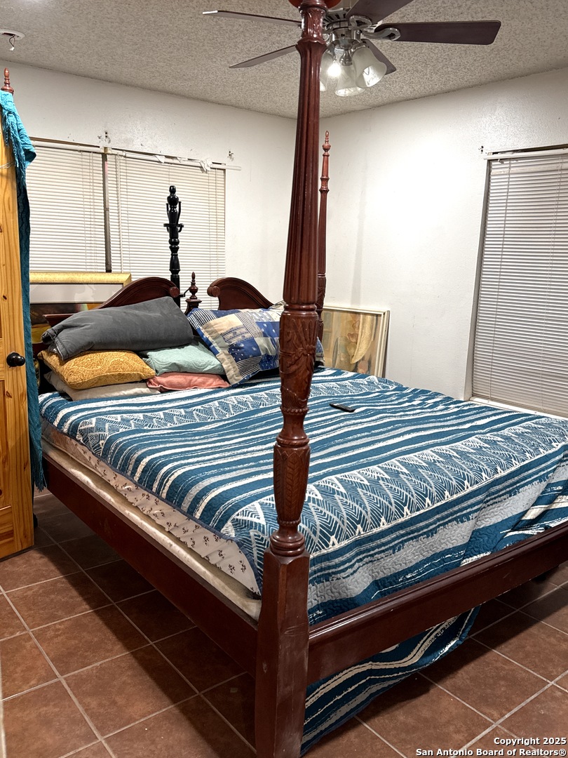 713 Boone Street Uvalde, TX 78801 - Photo 20 of 31 a bedroom with bed and a ceiling fan