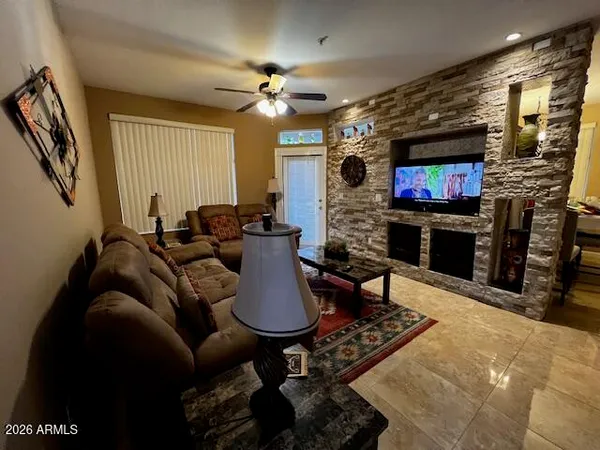 a living room with furniture a flat screen tv and a fireplace