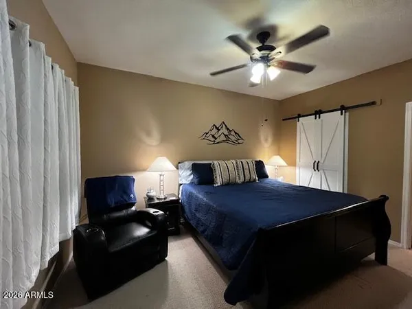 a bedroom with a bed and a ceiling fan