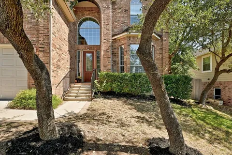 a view of a yard in front of a house with large tree