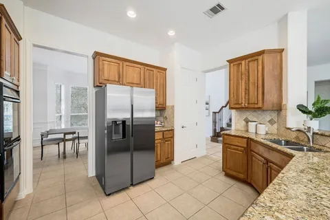 a kitchen with granite countertop a refrigerator and a sink