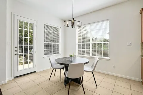 a dining room with furniture a chandelier and window