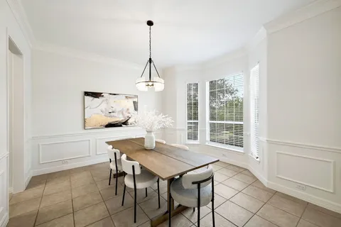 a view of a dining room and livingroom with furniture wooden floor a chandelier