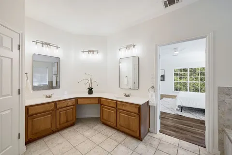 a large white bathroom with a sink mirror and a bathtub