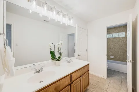 a bathroom with a sink vanity granite and a mirror