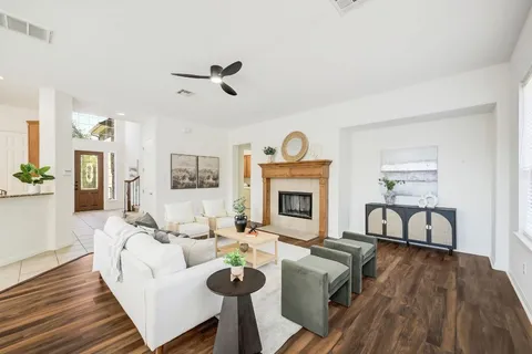 a living room with furniture a fireplace and wooden floor