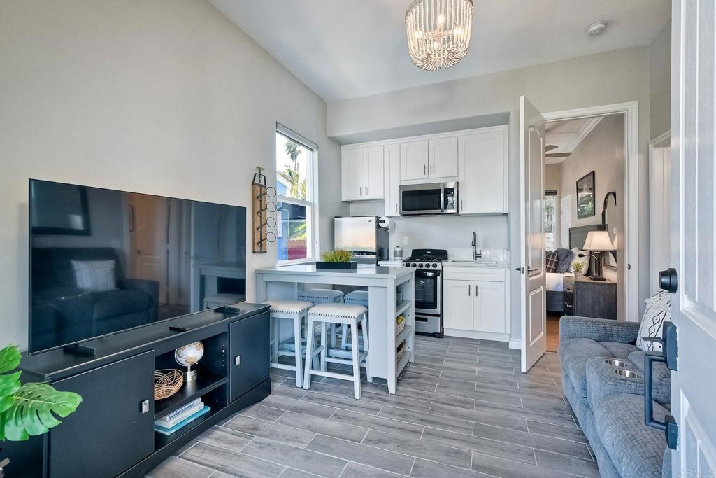 2559 Fire Mountain Drive Oceanside, CA 92054 - Photo 35 of 43 a kitchen with stainless steel appliances granite countertop a refrigerator oven a sink dishwasher and white cabinets with wooden floor