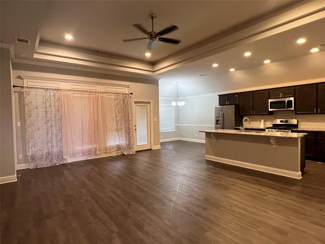a view of kitchen with microwave and refrigerator
