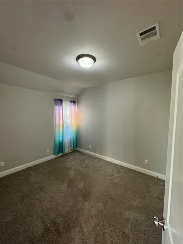 an empty room with yellow lighting and windows