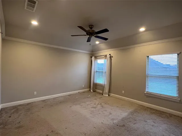 a view of an empty room and a ceiling fan window