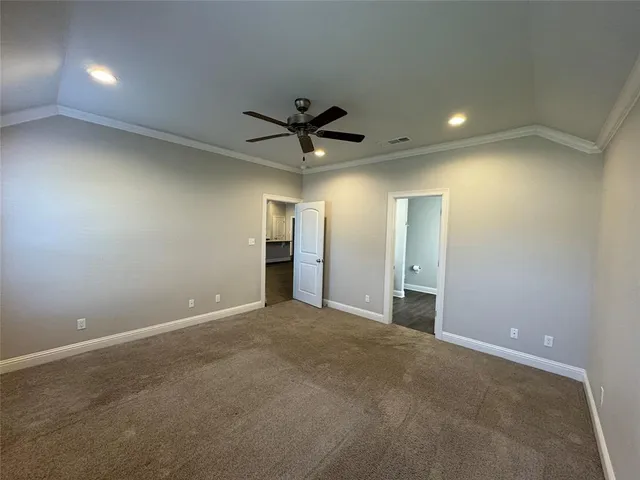 an empty room with closet and a ceiling fan
