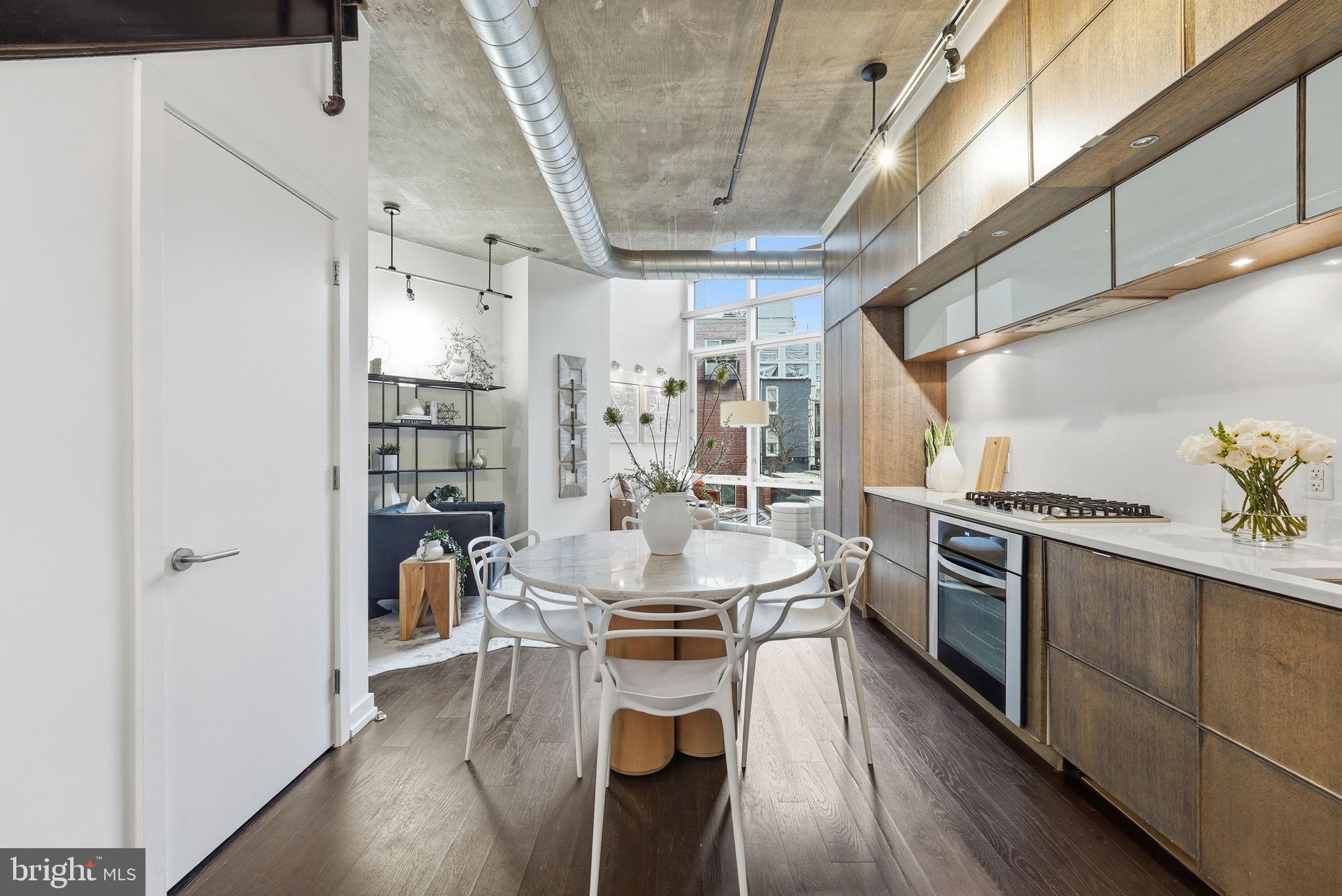 1515 15th Street Northwest, Unit 234 Washington, DC 20005 - Photo 10 of 33 a kitchen with stainless steel appliances a dining table chairs stove and cabinets