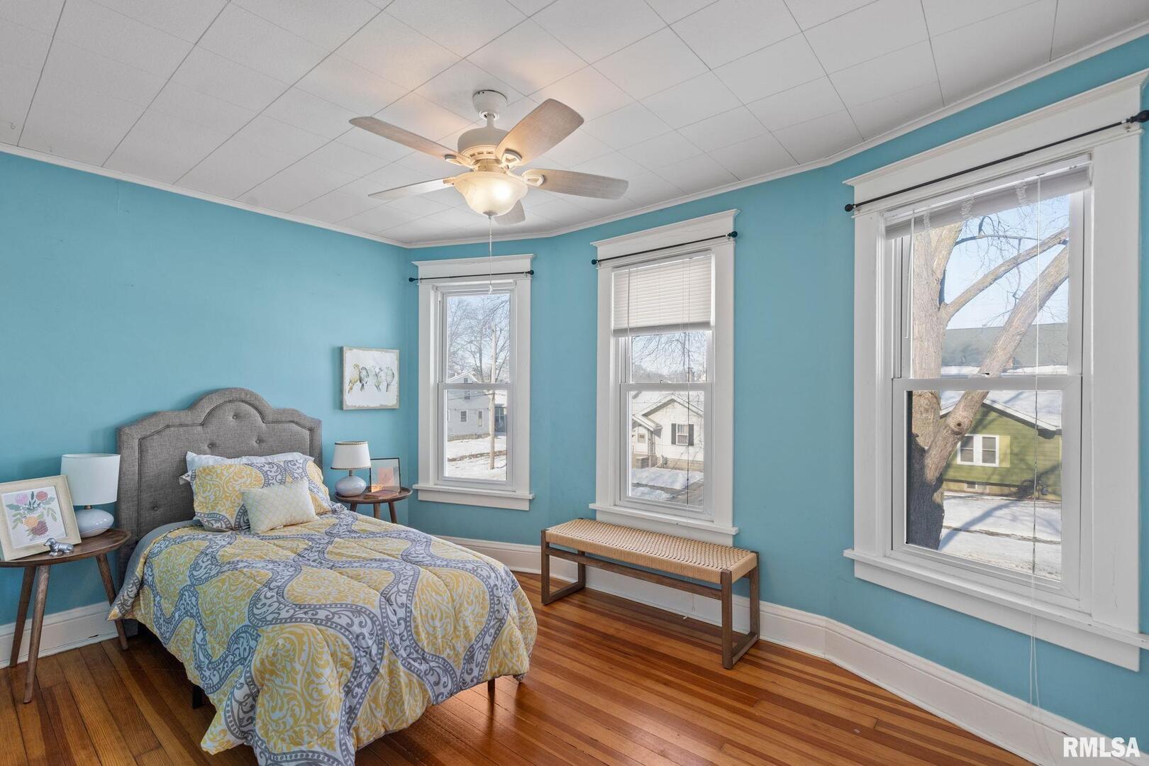 1602 37th Street Rock Island, IL 61201 - Photo 20 of 37 a bedroom with a bed wooden floor and windows