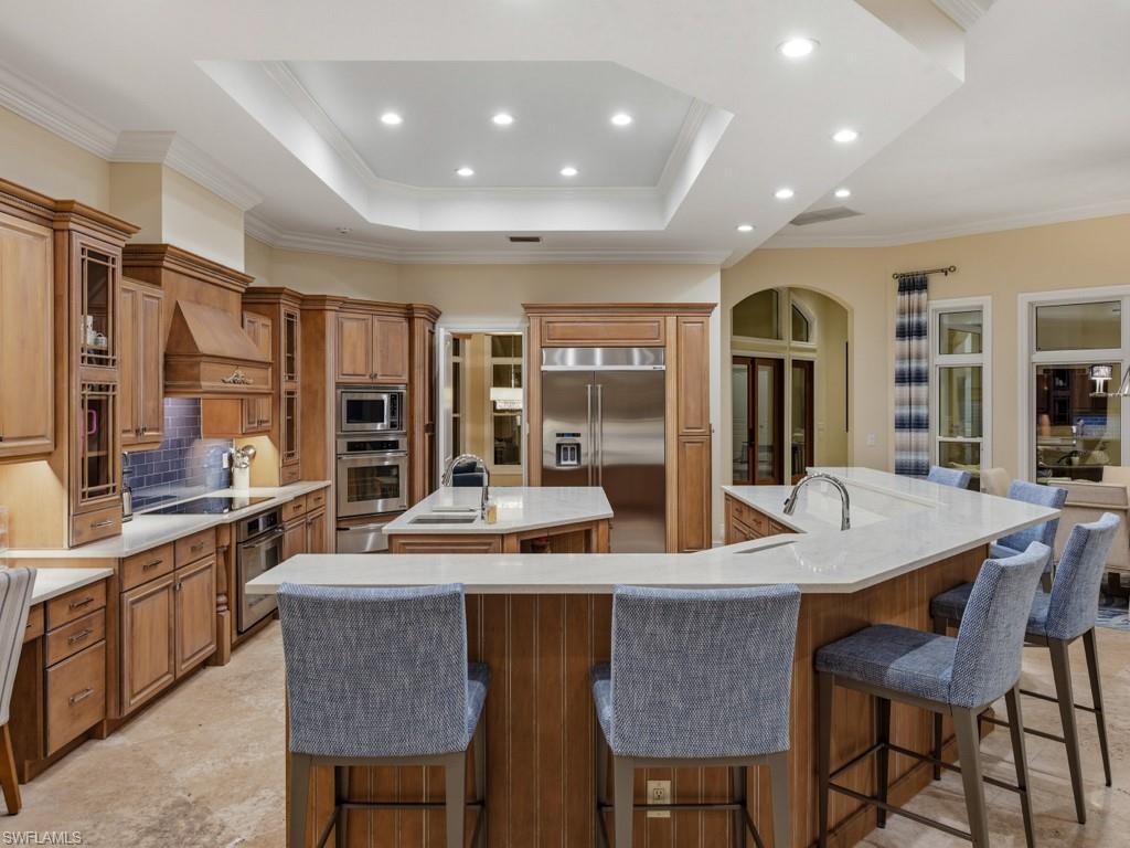 7051 Hunters Road Naples, FL 34109 - Photo 11 of 49 a dining hall with stainless steel appliances granite countertop a stove a sink a oven a dining table and chairs