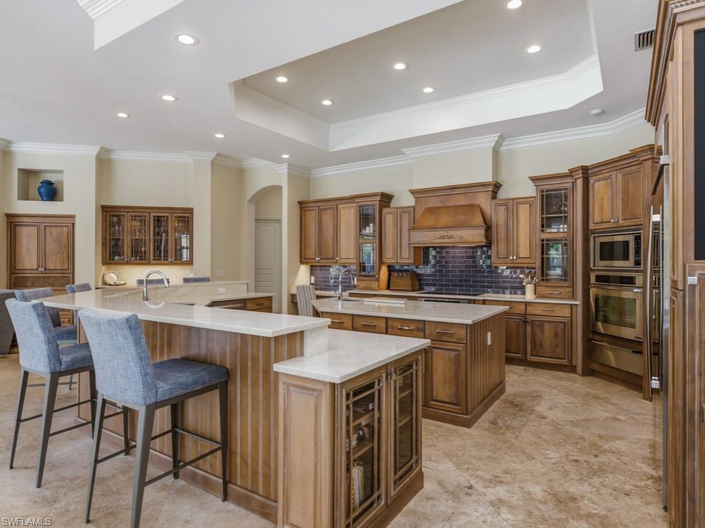 7051 Hunters Road Naples, FL 34109 - Photo 13 of 49 a kitchen with stainless steel appliances granite countertop a stove and a refrigerator