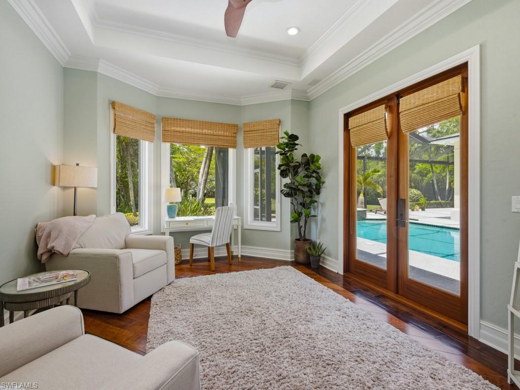 7051 Hunters Road Naples, FL 34109 - Photo 21 of 49 a living room with furniture and a large window