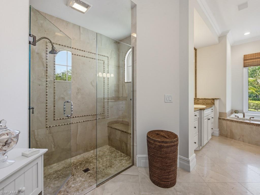 7051 Hunters Road Naples, FL 34109 - Photo 23 of 49 a bathroom with a tub a sink and a shower