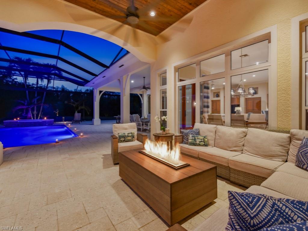 7051 Hunters Road Naples, FL 34109 - Photo 24 of 49 a view of a patio with couches and chairs under an umbrella