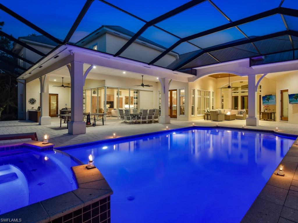 7051 Hunters Road Naples, FL 34109 - Photo 25 of 49 a swimming pool with outdoor seating