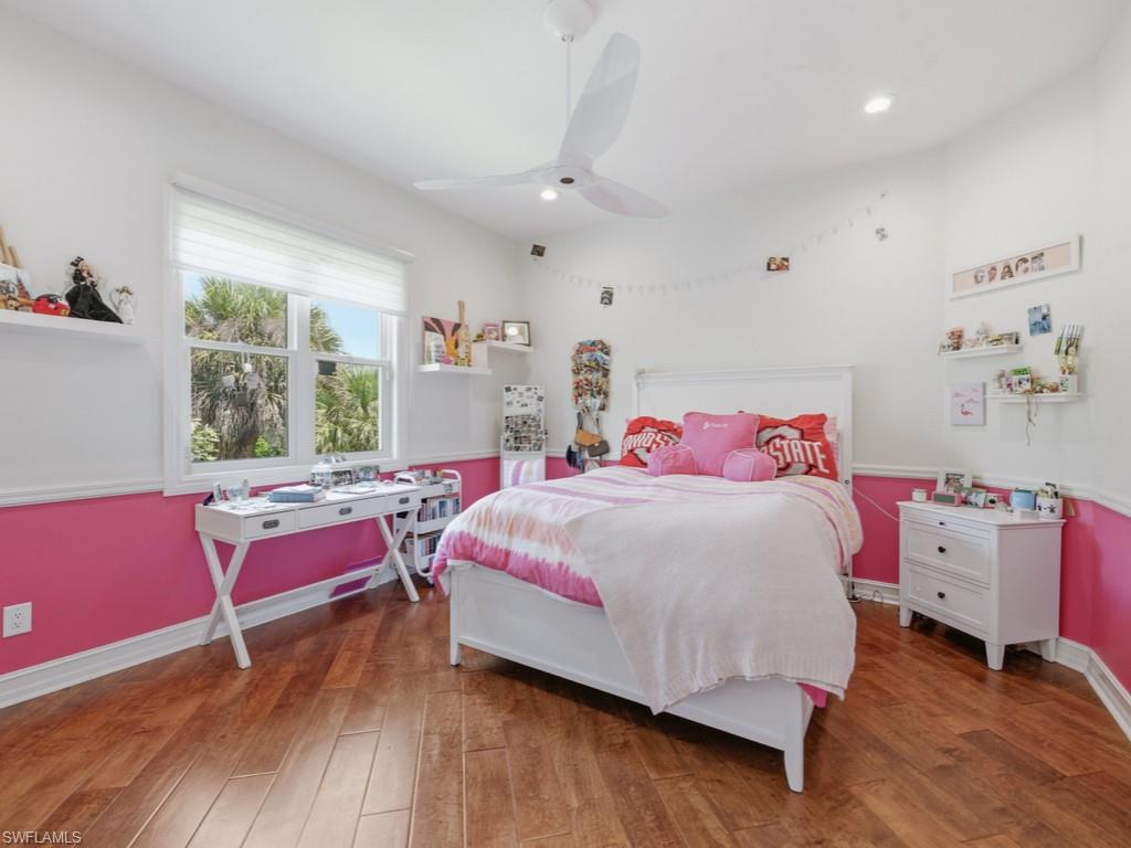7051 Hunters Road Naples, FL 34109 - Photo 27 of 49 a bedroom with a bed and wooden floor