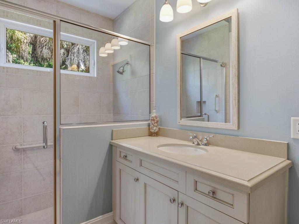 7051 Hunters Road Naples, FL 34109 - Photo 30 of 49 a bathroom with a sink and a mirror