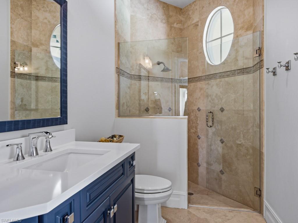 7051 Hunters Road Naples, FL 34109 - Photo 32 of 49 a bathroom with a sink a toilet and a mirror